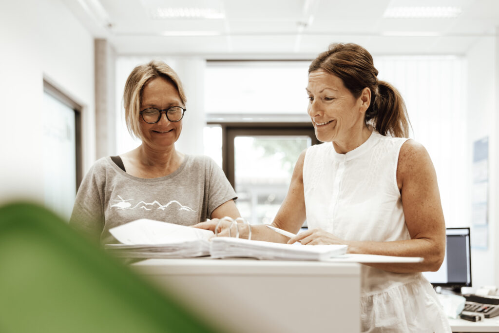 Zwei Frauen schauen in ein Ordner